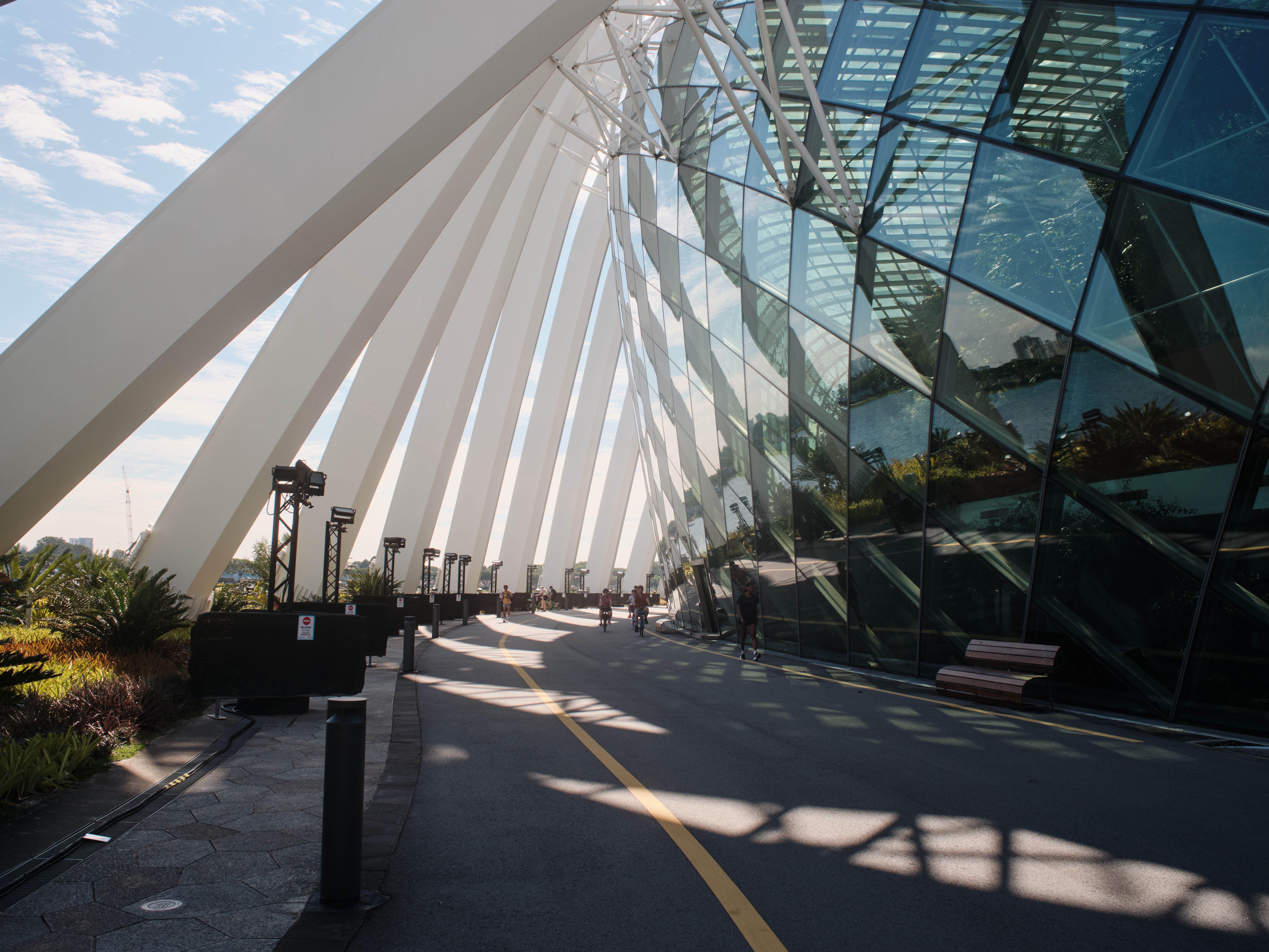 Sleek architecture with geometric glass facade and overhanging canopy on a sunny day.