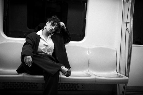 Free Woman in fashionable oversized suit posing in a subway car. Artful, modern vibe. Stock Photo