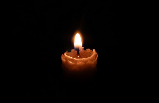 A single lit candle in a dark room, creating a warm ambiance.