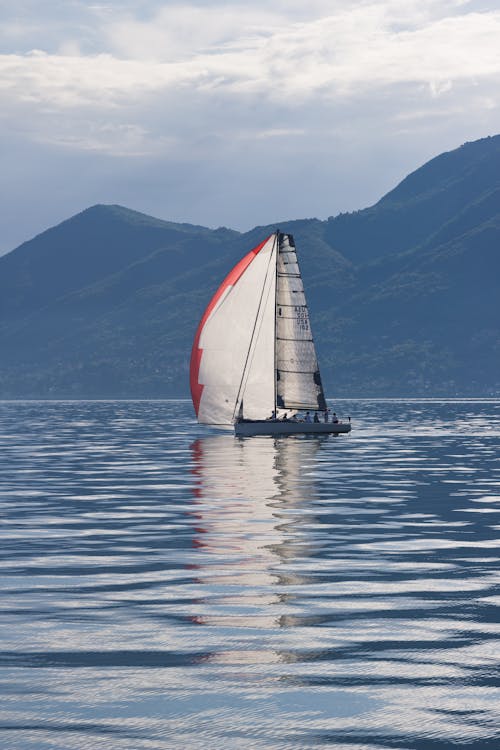 Foto Perahu Layar Dekat Pegunungan Pada Siang Hari