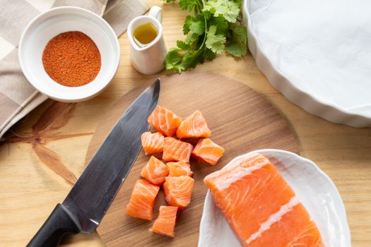 Top view of fresh salmon being prepared with spices and oil, perfect for a gourmet meal.