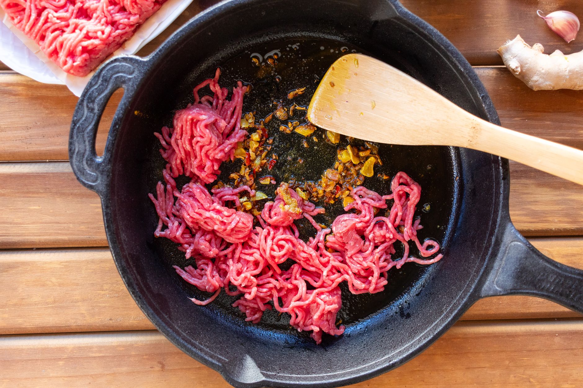 Meal prep containers filled with cooked ground beef and vegetables