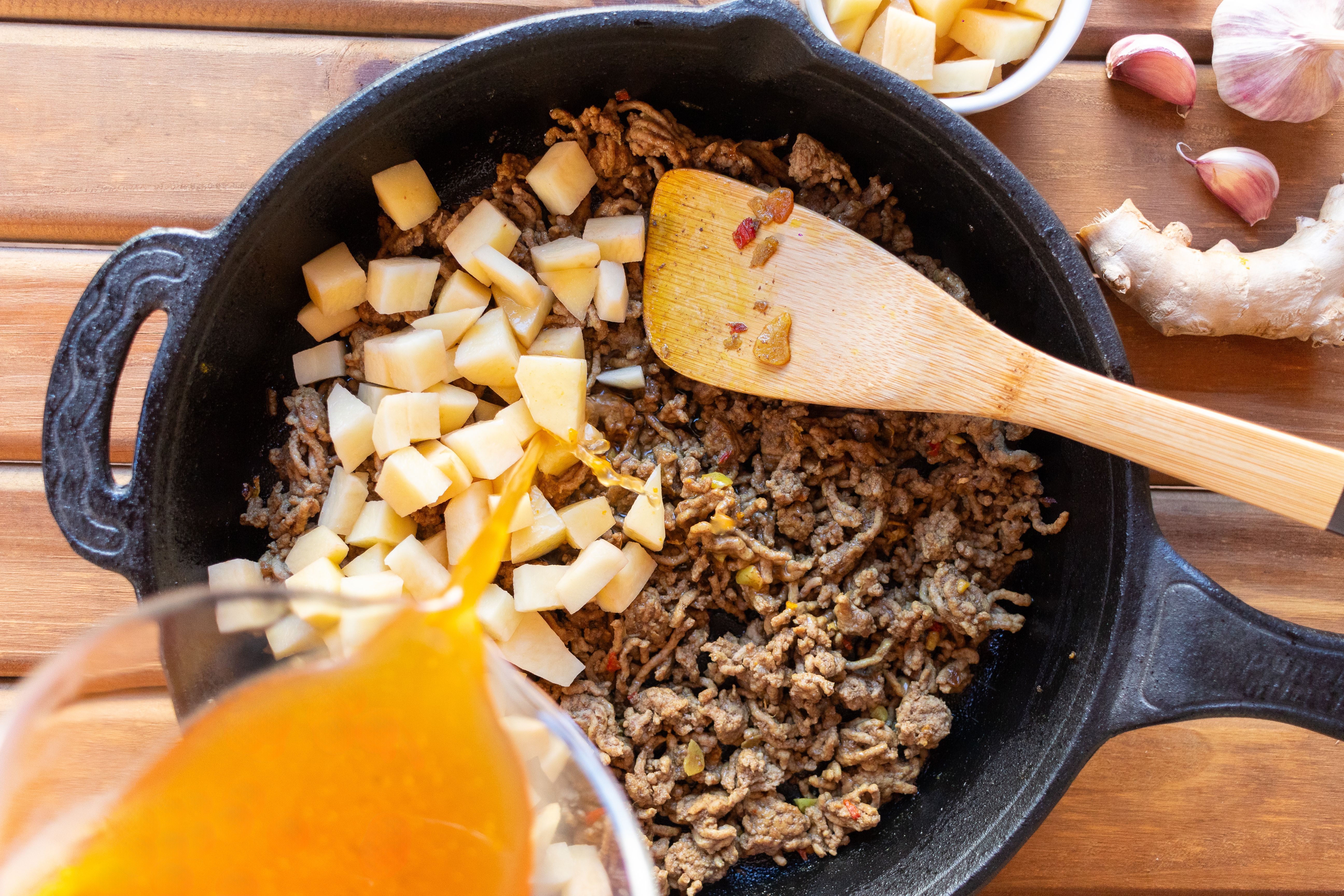 Skillet with ground beef and vegetables simmering with diced tomatoes