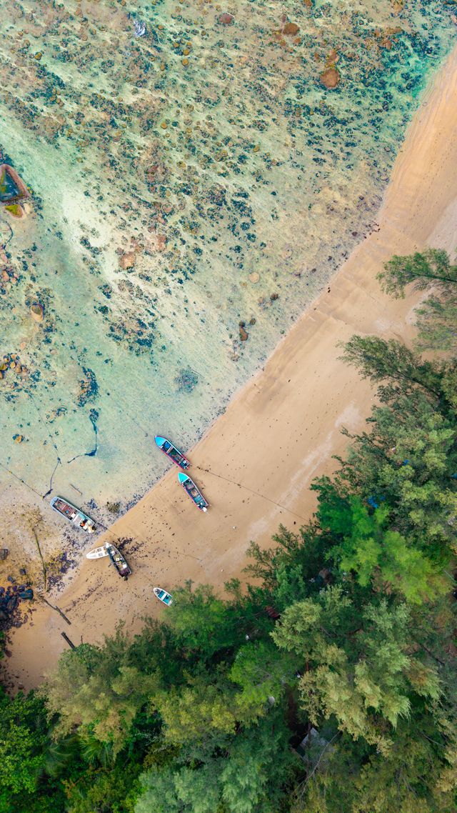 普吉岛南部海滩的航拍图，画面中有长尾船