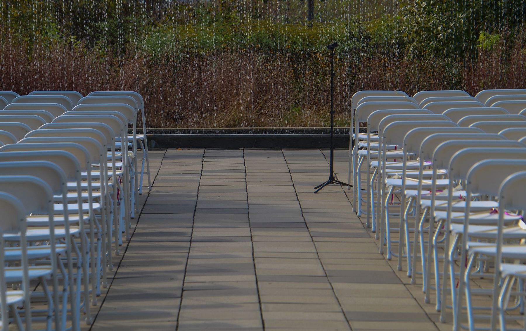 Outdoor wedding ceremony audio setup with microphone and chairs