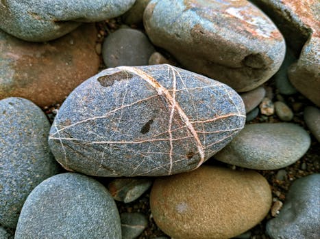 Detailed view of textured river stones in North Kalimantan, Indonesia, showcasing natural patterns.