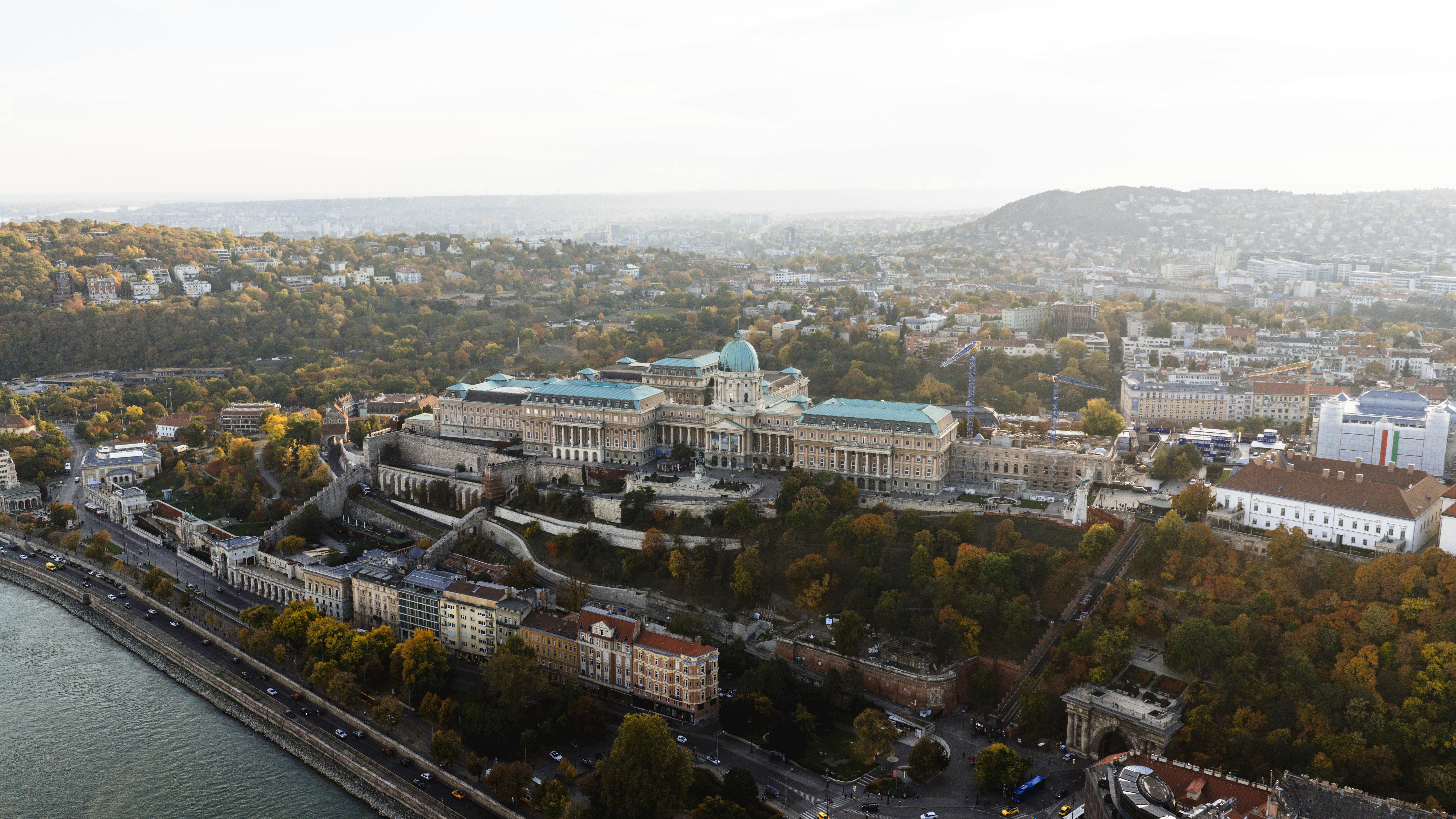 Drone shot of the historical Buda Castle overlooking the Danube River in Budapest, Hungary.