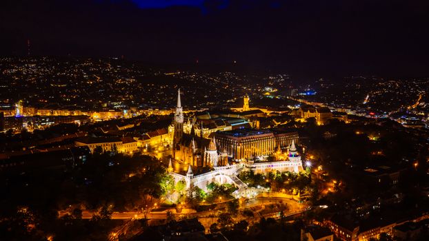 Captivating aerial view of Budapest at night featuring Matthias Church and the Fisherman's Bastion.