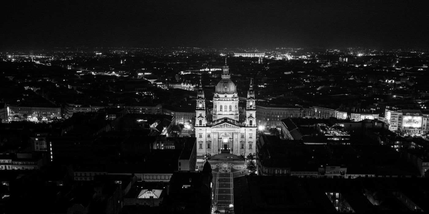 Black and white aerial view of St. Stephen's Basilica illuminated at night in Budapest, Hungary.