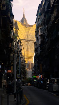 Dramatic street view of Macau with the Grand Lisboa Hotel in golden light.