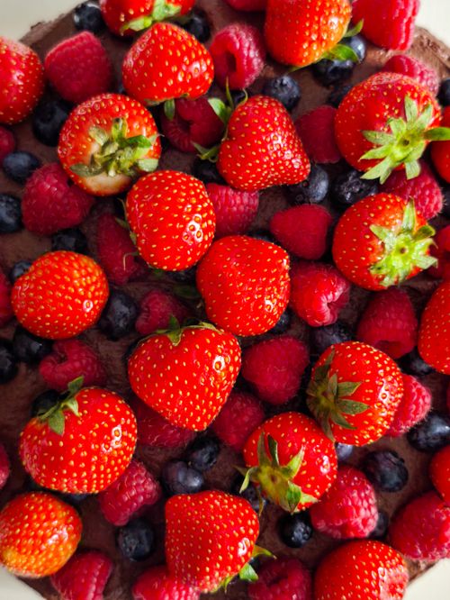 Free A vibrant chocolate tart topped with fresh strawberries, raspberries, and blueberries. Stock Photo