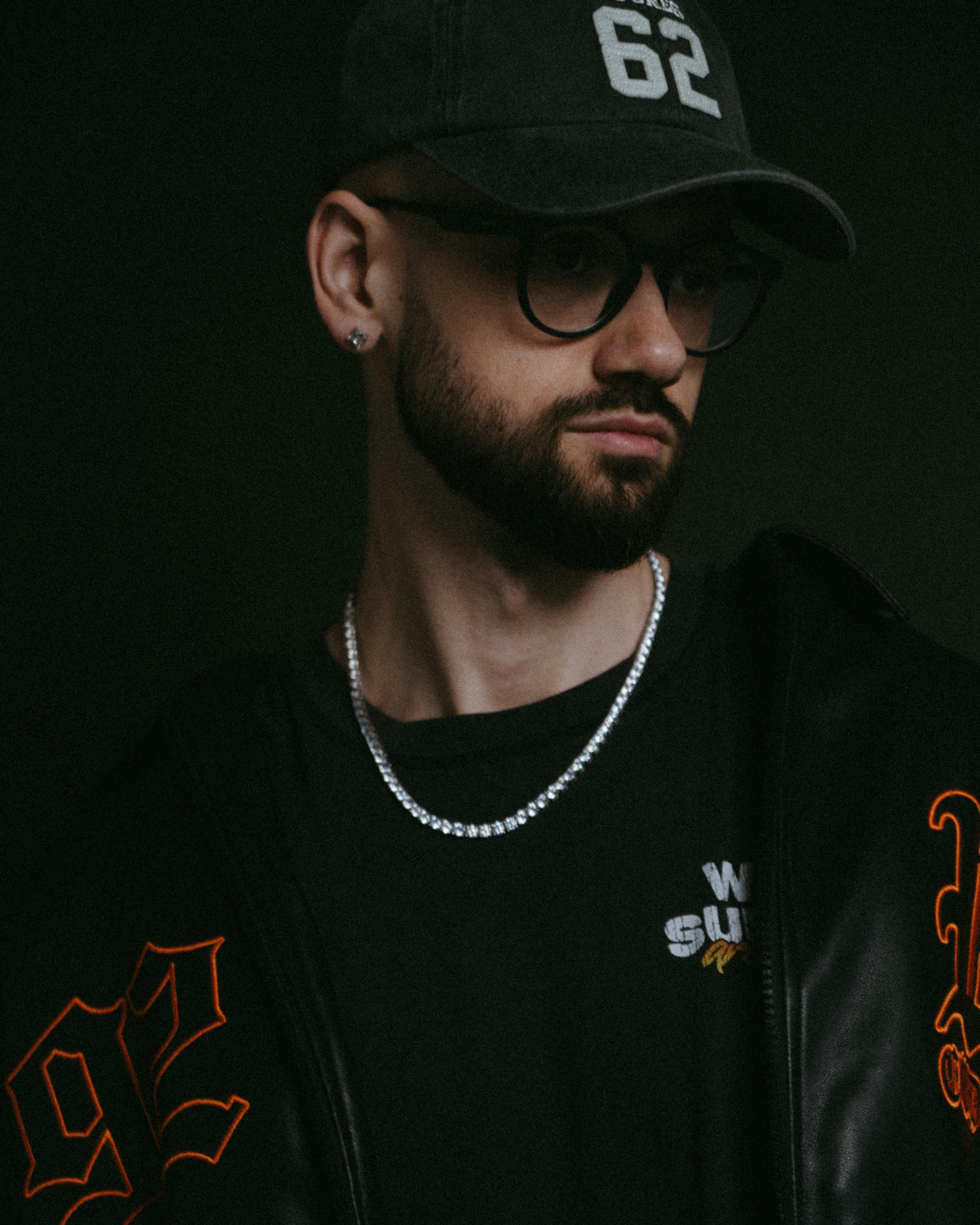 Portrait of a fashionable young man in dark clothing and accessories.