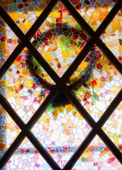Free Colorful stained glass window featuring abstract mosaic patterns with vivid hues. Stock Photo