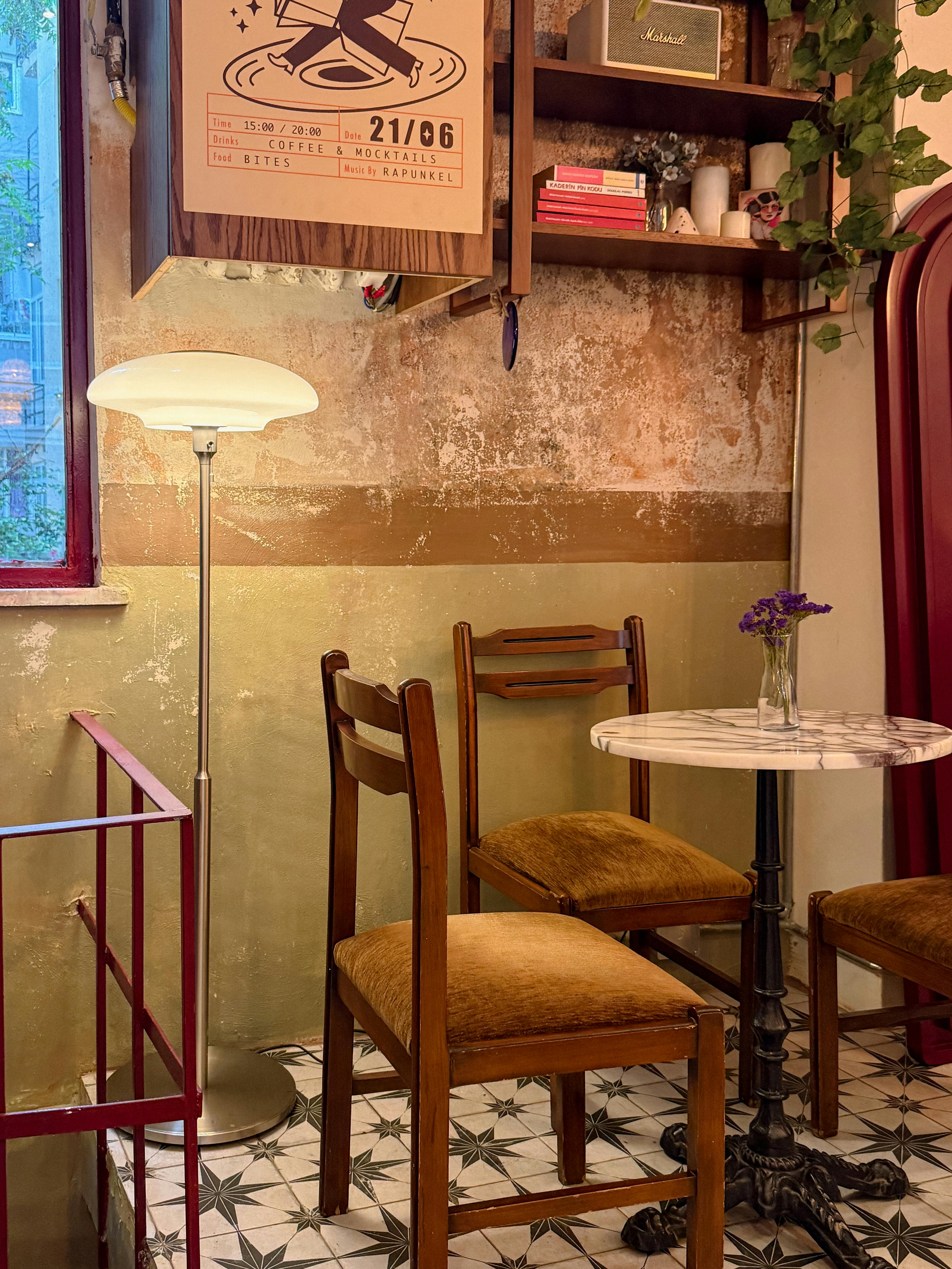 Gratuit Interior fermecător al unei cafenele vintage, cu scaune din lemn și o masă de marmură, sub o lumină difuză. Fotografie de stoc