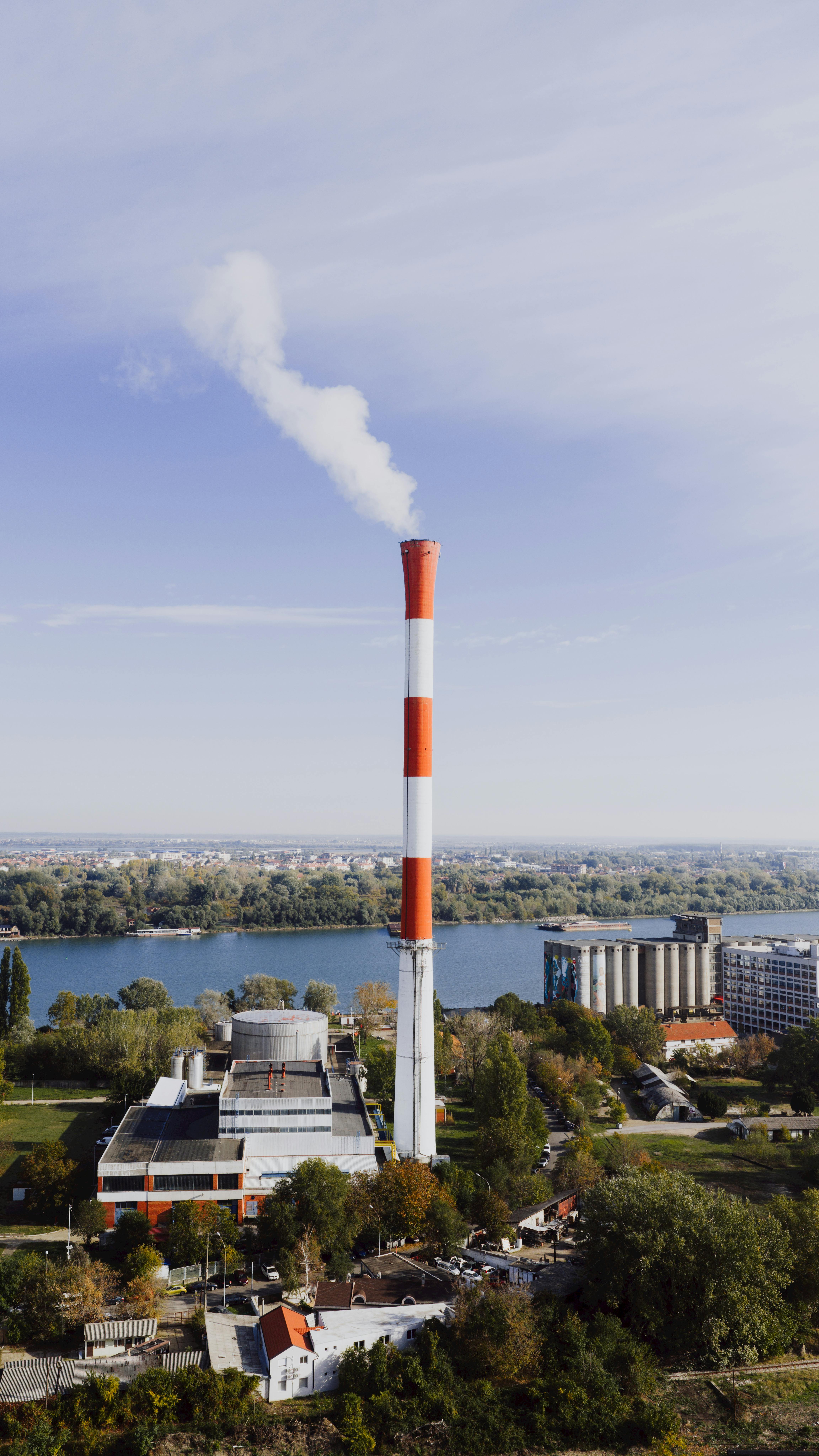 무료 맑은 푸른 하늘을 배경으로 세르비아 베오그라드의 굴뚝이 있는 화력발전소를 공중에서 본 모습입니다. 스톡 사진