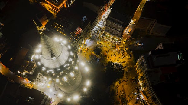 Stunning aerial view of the illuminated Galata Tower in Istanbul at night, surrounded by bustling city streets.