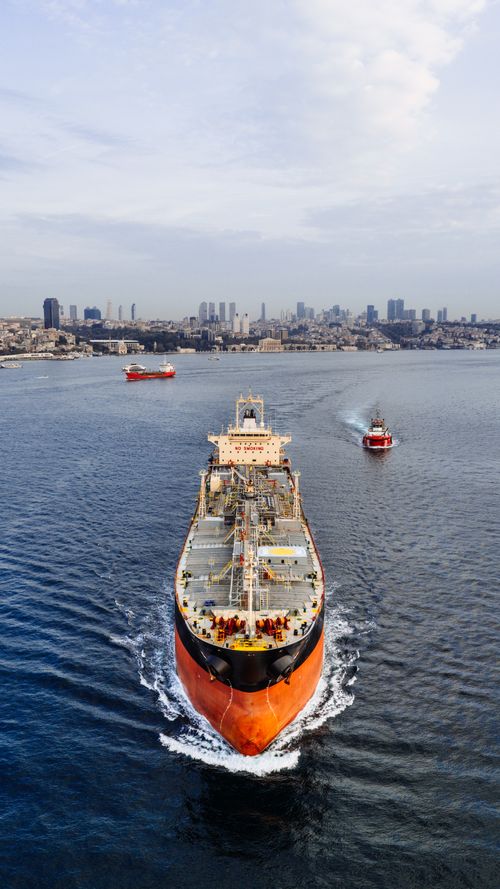 Free Aerial shot of a cargo ship navigating through Istanbul with the city skyline in the background. Stock Photo