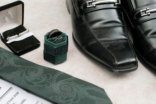 Sophisticated layout of men's wedding accessories, including shoes, cufflinks, and rings.