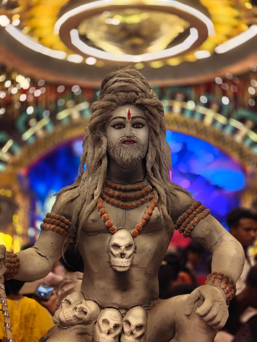 Free Intricate statue of Lord Shiva adorned with skulls at a colorful indoor festival. Stock Photo