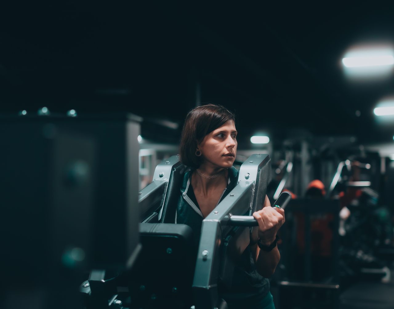 a woman intensely working out on a machine in a modern gym showcasing