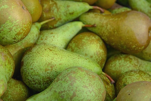 A vibrant close-up image of fresh, ripe green pears piled together.