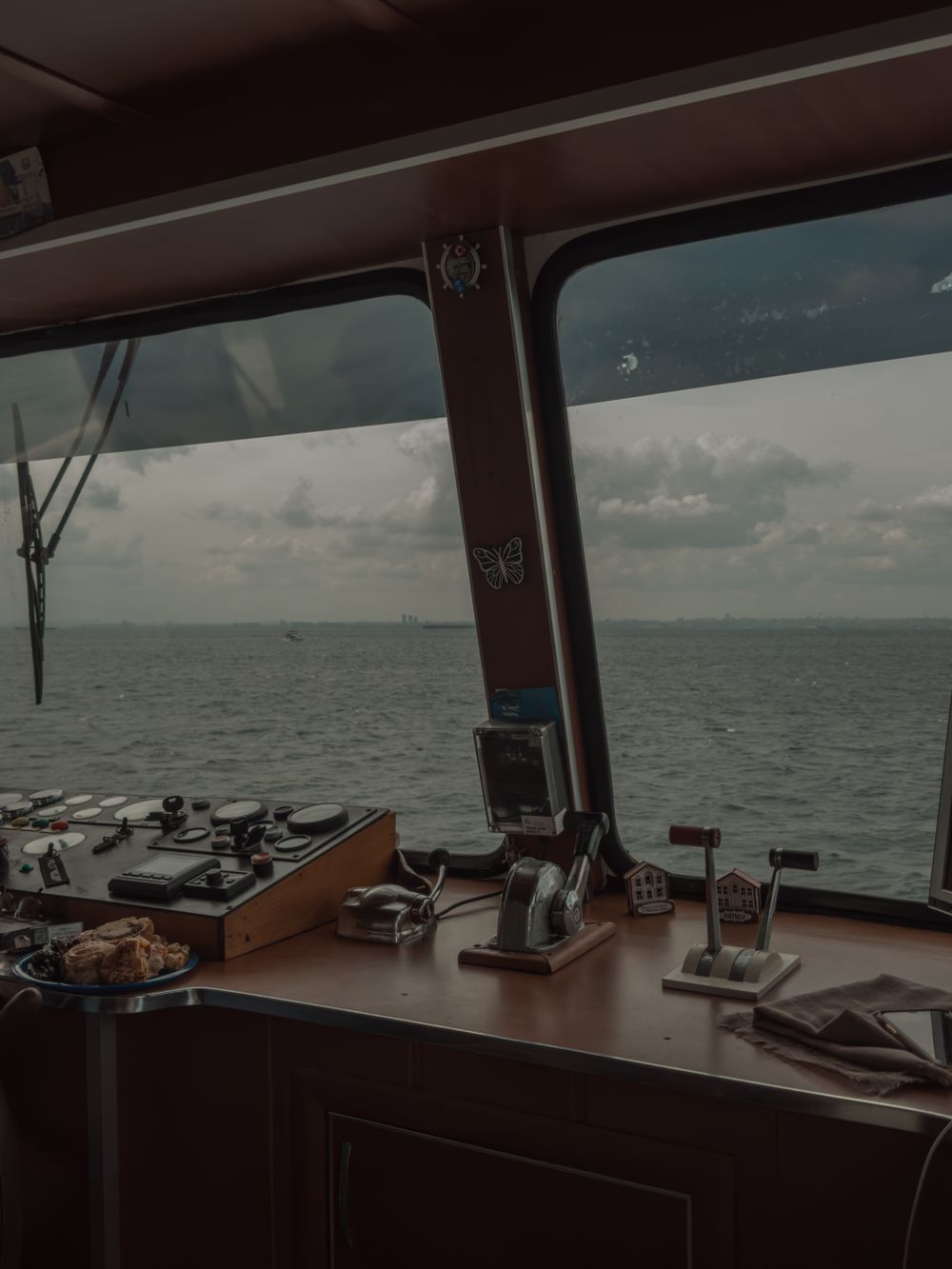 Halcyon nav station after refit — dark-wood desk and instruments by sea windows