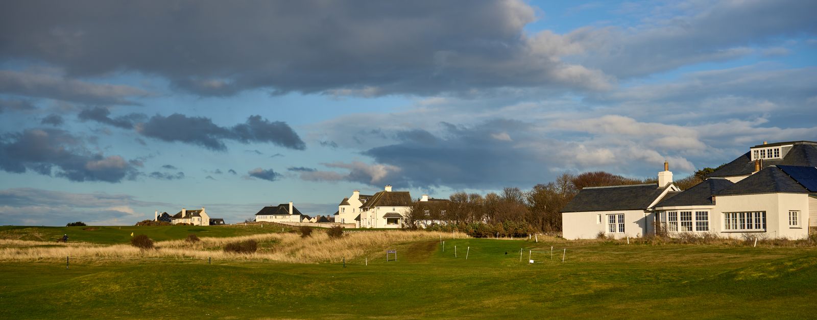 Beautiful spring landscape of Gosford Bay's charming cottages against a dramatic sky in East Lothian, Scotland.