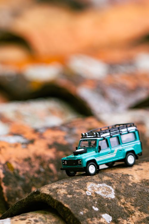 Free A detailed miniature Land Rover model placed on textured stone tiles, creating a rustic outdoor adventure scene. Stock Photo