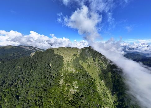 Stunning aerial shot of a verdant mountain ridge with clouds in Taiwan.