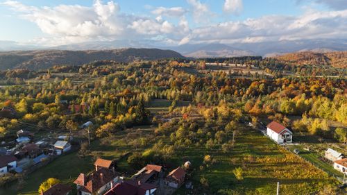 Free Explore a vibrant autumn landscape from above, showcasing colorful foliage and rural houses. Stock Photo