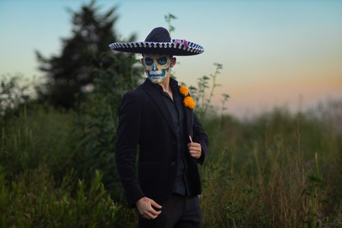 Free A man in Catrina makeup and charro outfit celebrates Día de Muertos in a natural setting. Stock Photo