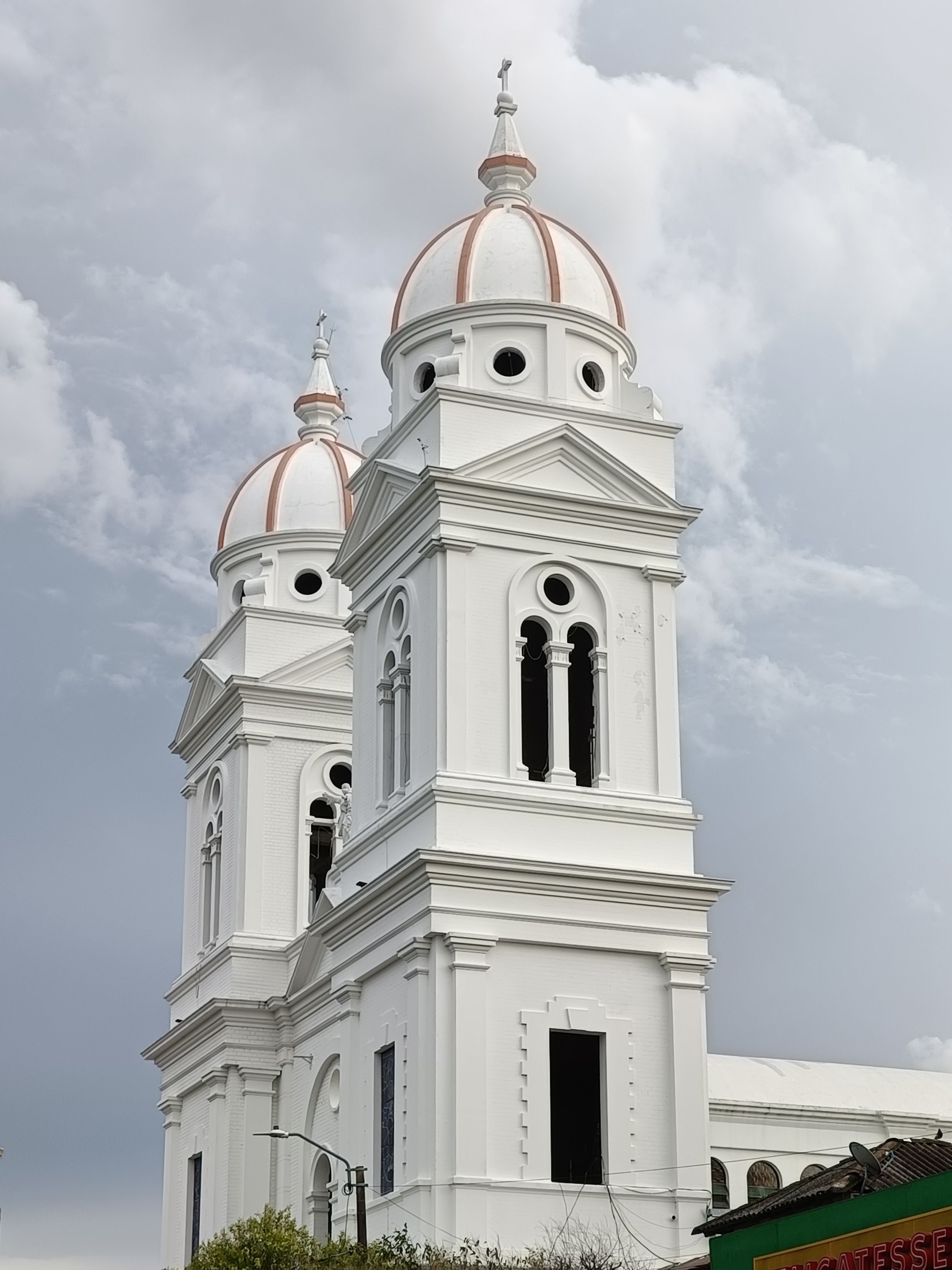 Beautiful white church towers with domes against a cloudy sky