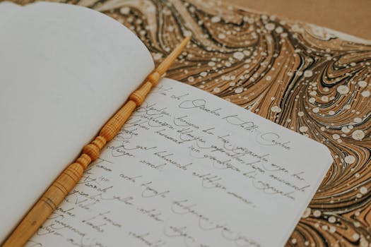 Open notebook with elegant handwriting and decorative marbled background.