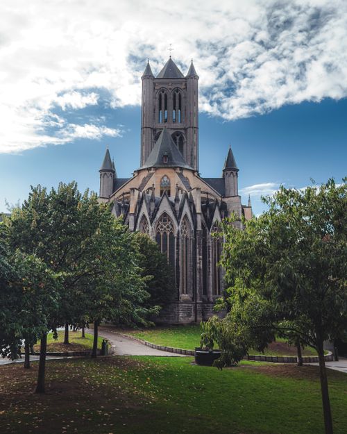 Free Beautiful view of St. Nicholas Church in Ghent, Belgium surrounded by lush greenery and clear blue sky. Stock Photo