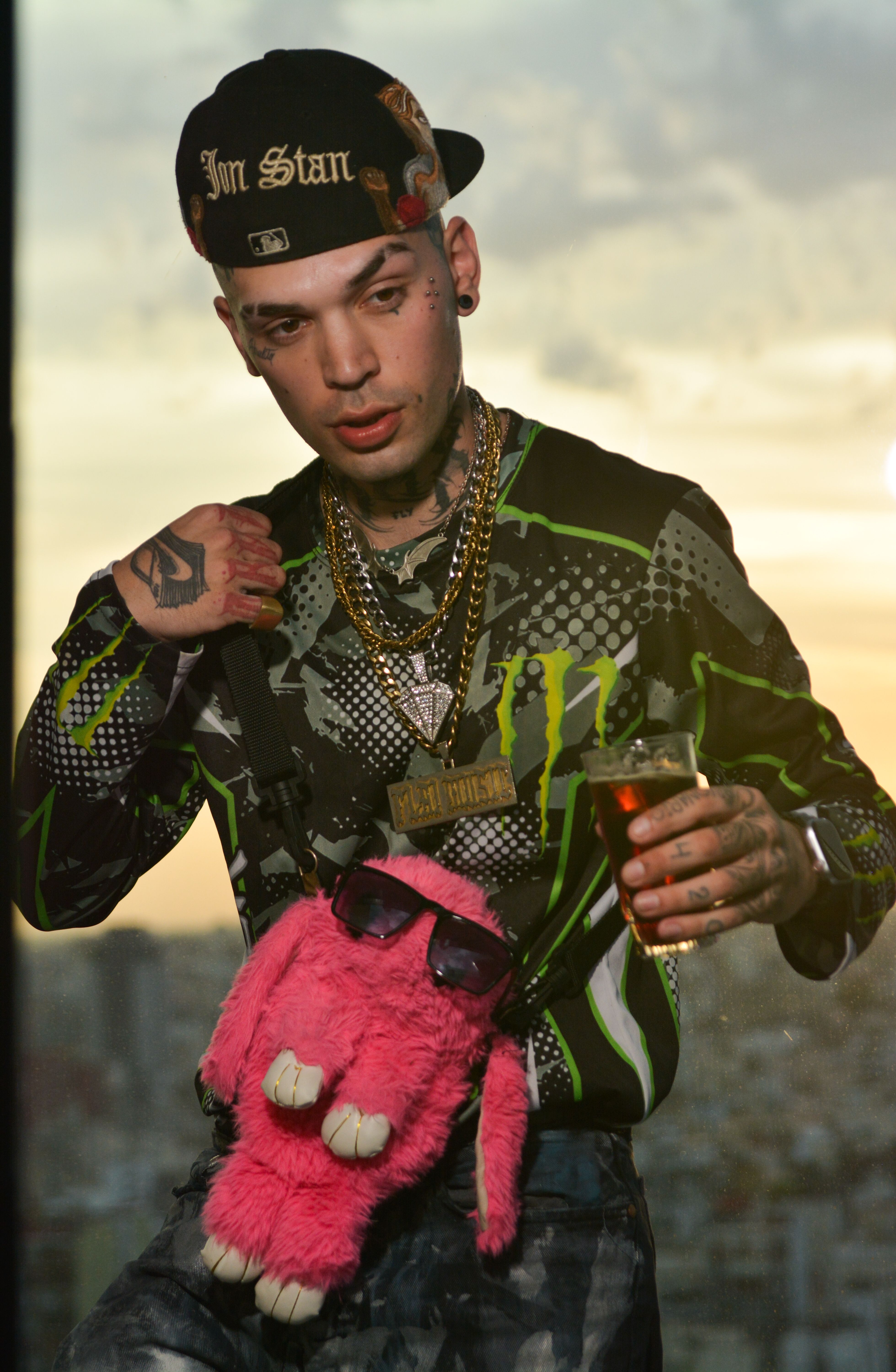 A stylish portrait of a tattooed man in urban fashion with unique accessories.