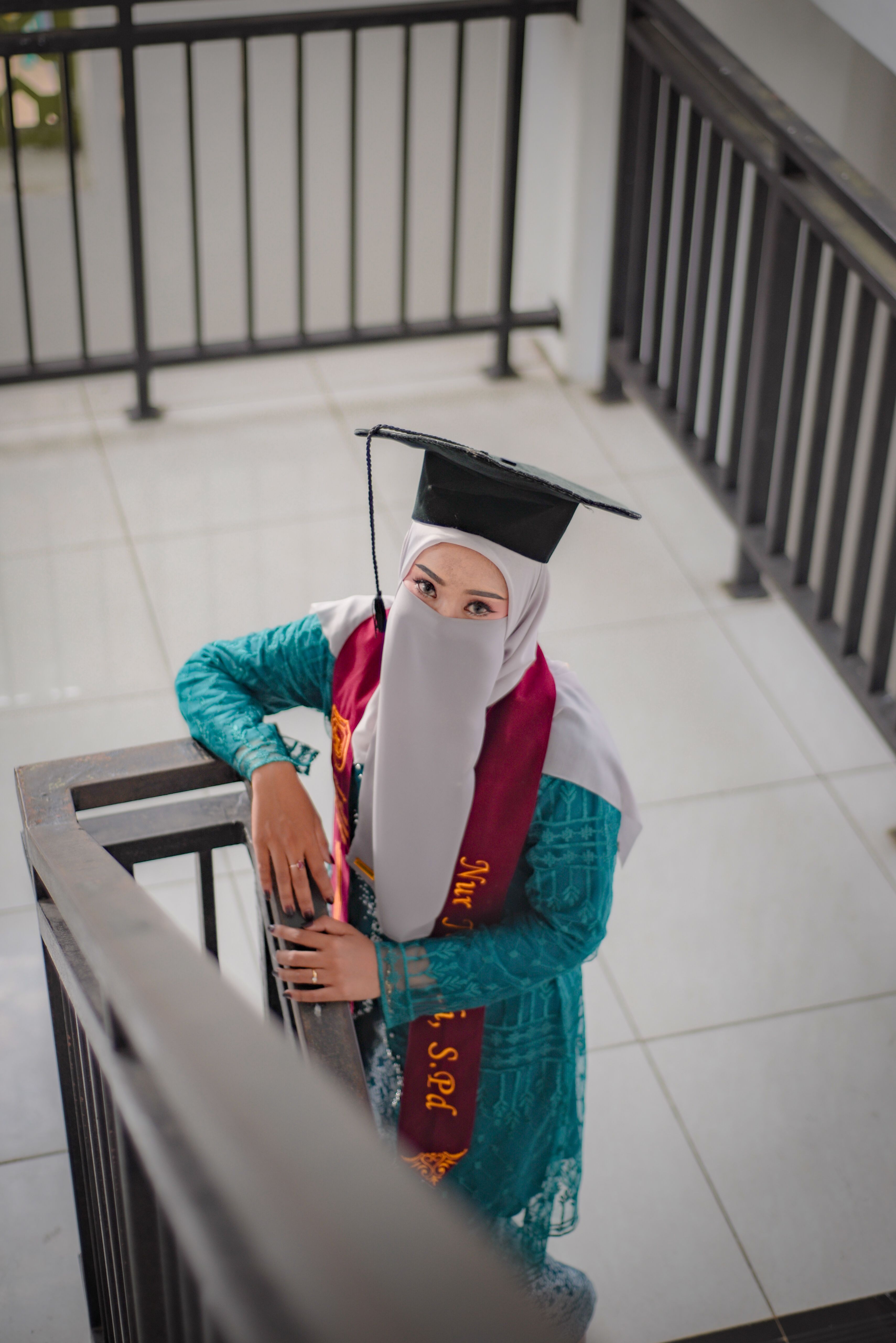 Indonesian Woman in Graduation Attire on Staircase