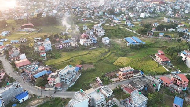 Aerial landscape of Bhaktapur, Nepal showcasing houses and green fields, captured during the day.