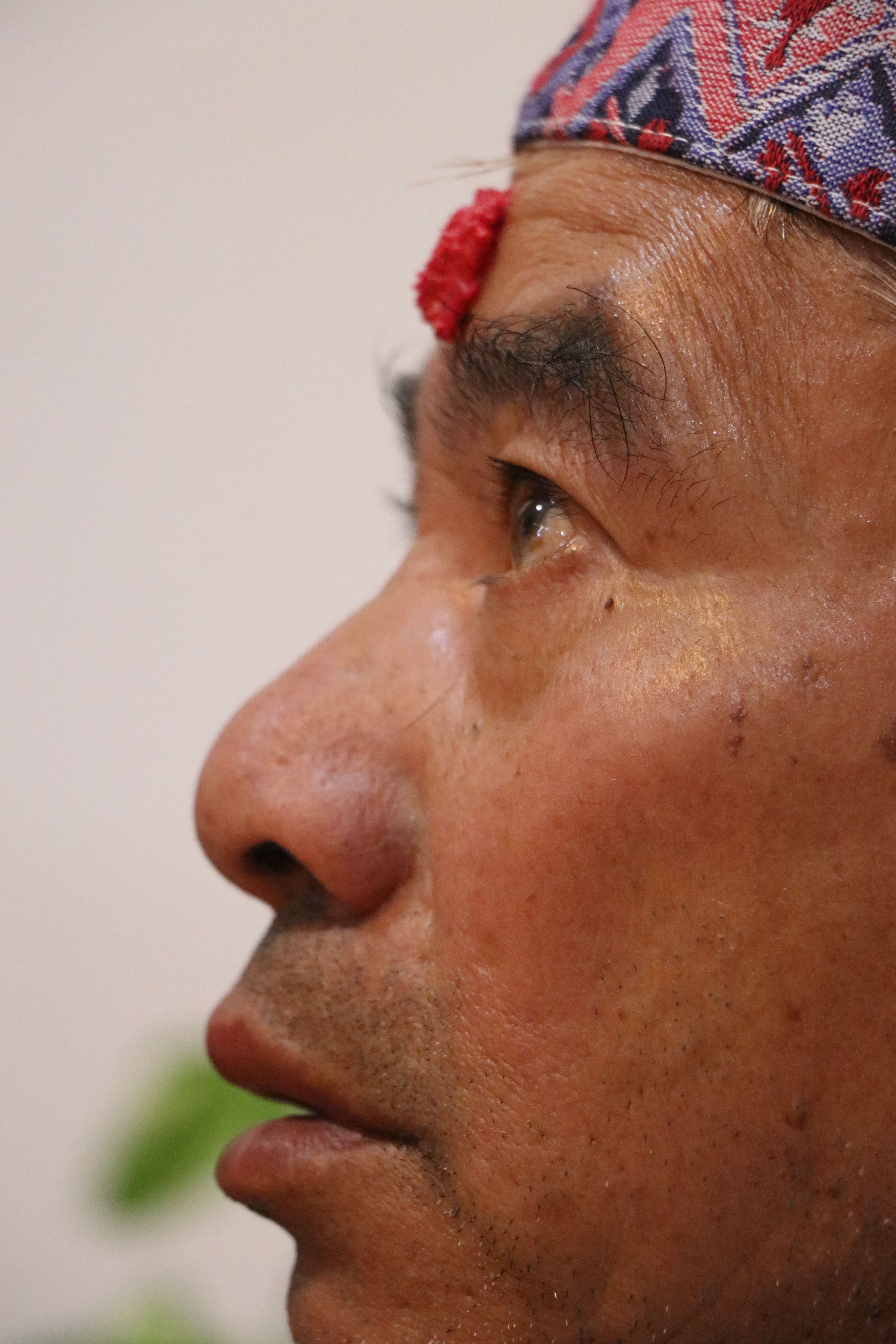 Profile of a senior Nepalese man wearing traditional attire, highlighting wisdom and cultural heritage.