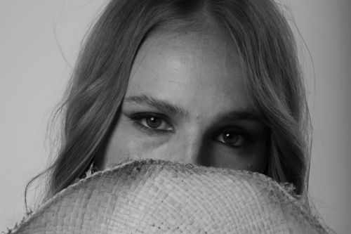 Free Intriguing black and white portrait of a woman partially hidden by a straw hat. Stock Photo