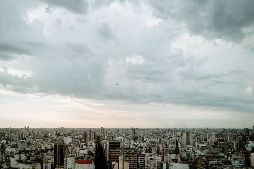 A panoramic aerial view of Buenos Aires skyline under a cloudy sky, emphasizing urban density.
