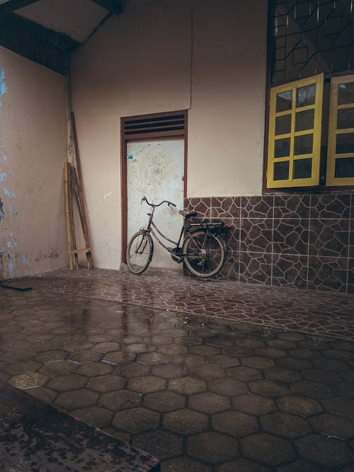 City bike parked near shabby house door