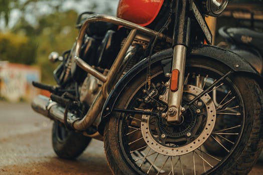 Detailed view of a vintage motorcycle's front wheel and disc brake, showcasing metal details.