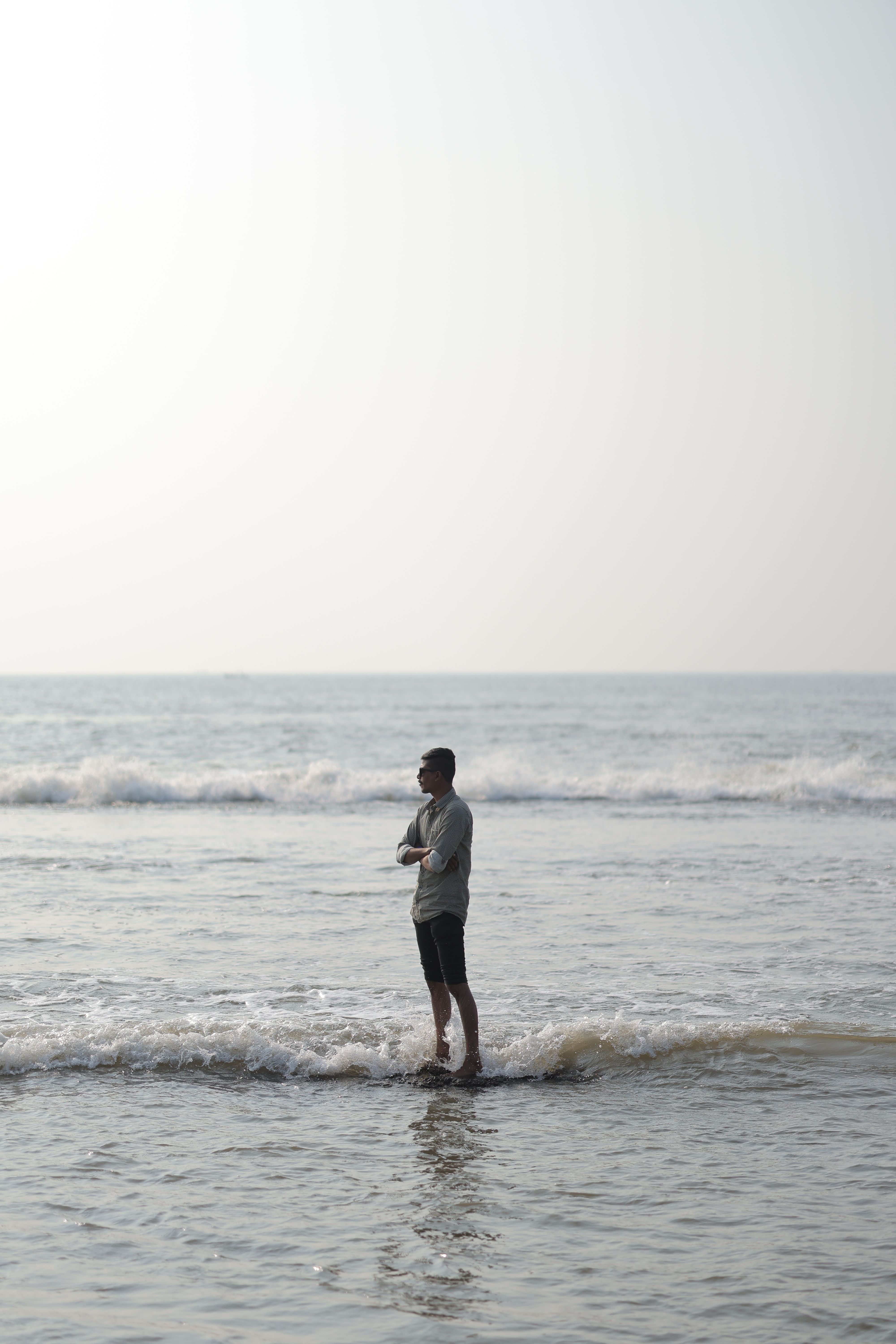 Contemplative Man Standing on Ocean Shoreline · Free Stock Photo