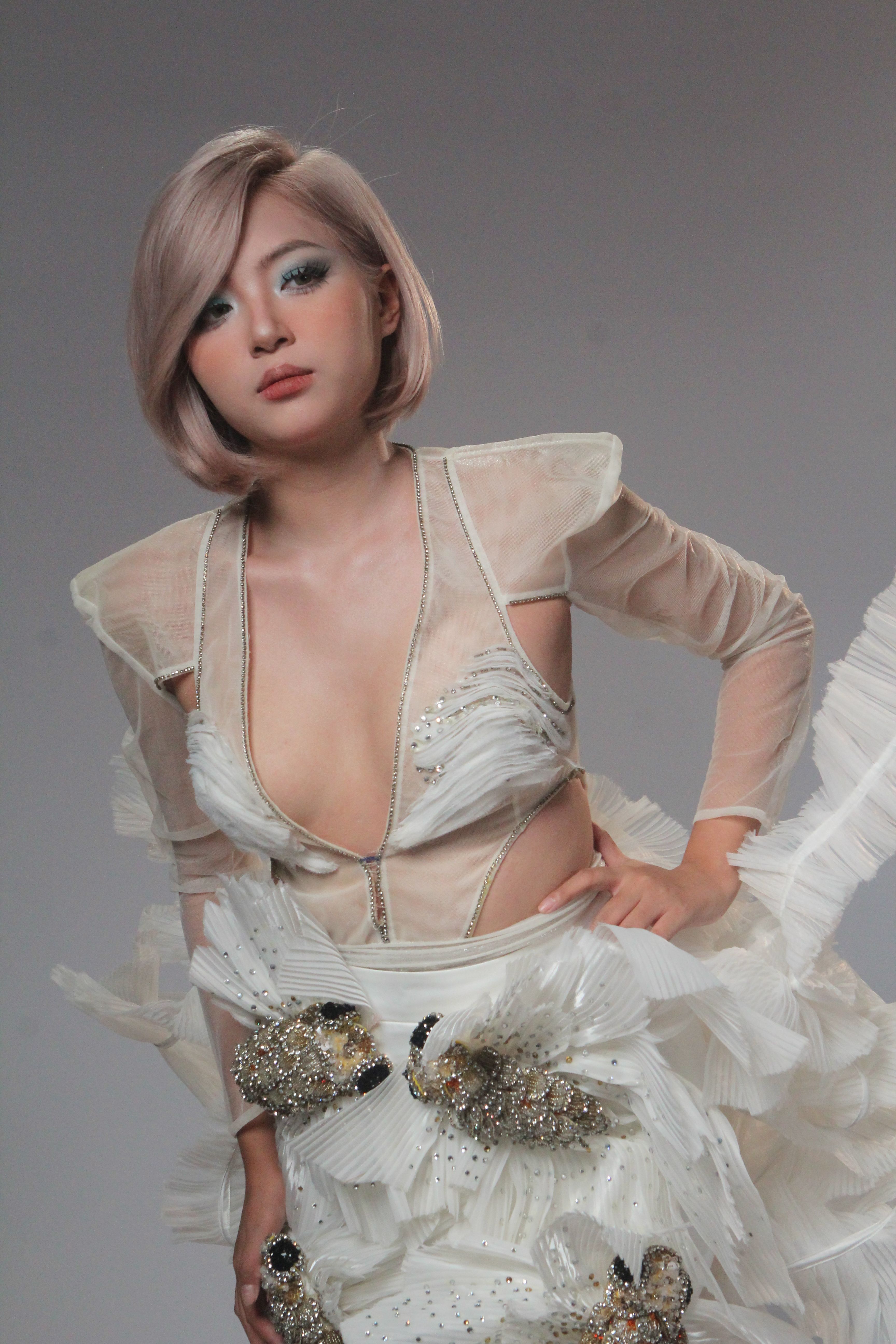 Artistic fashion portrait of woman in an elegant white dress with stylish design.