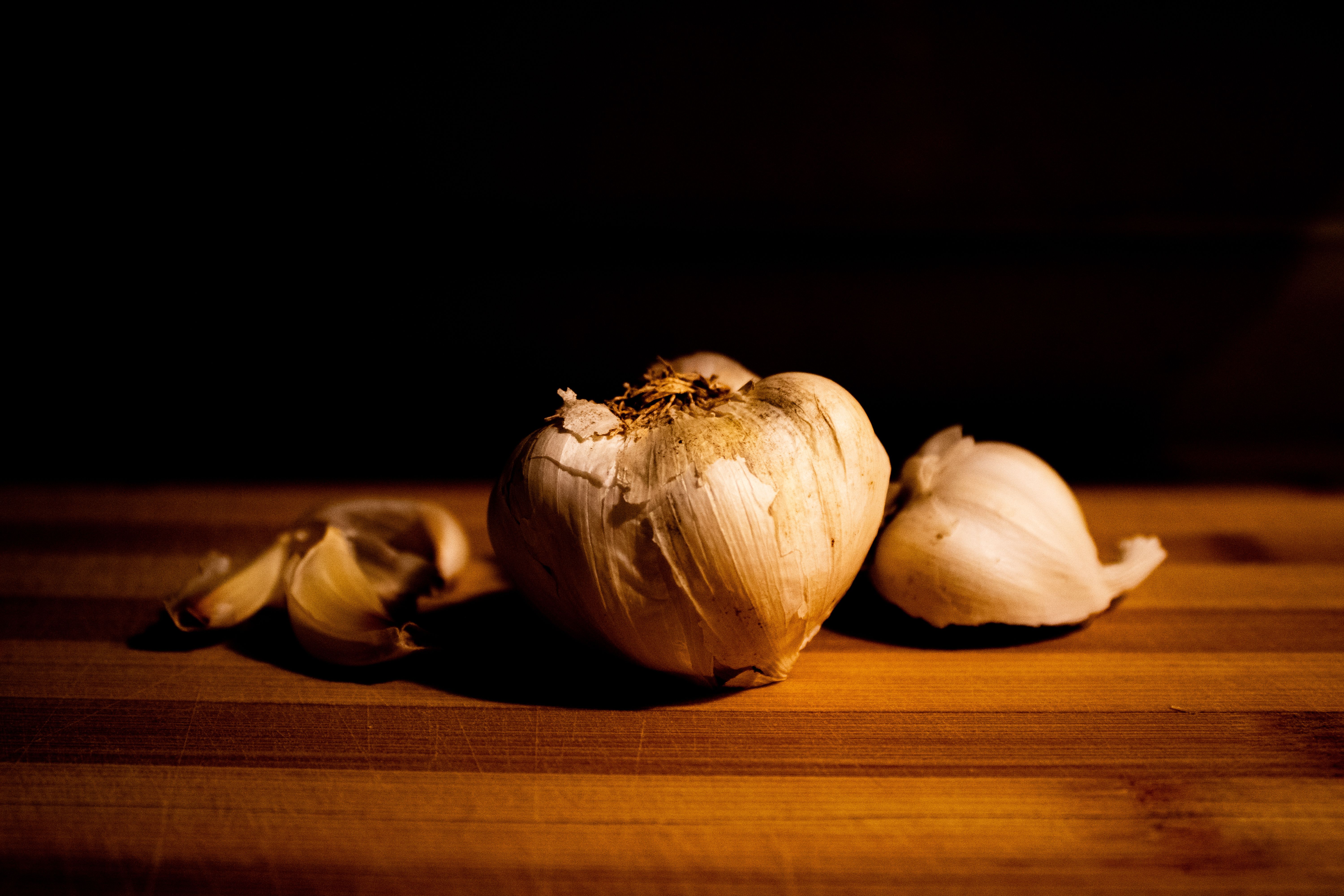 black garlic cloves on a wooden cutting board, soft focus background
