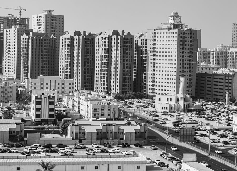Aerial view of Ajman cityscape with high-rise buildings in black and white.