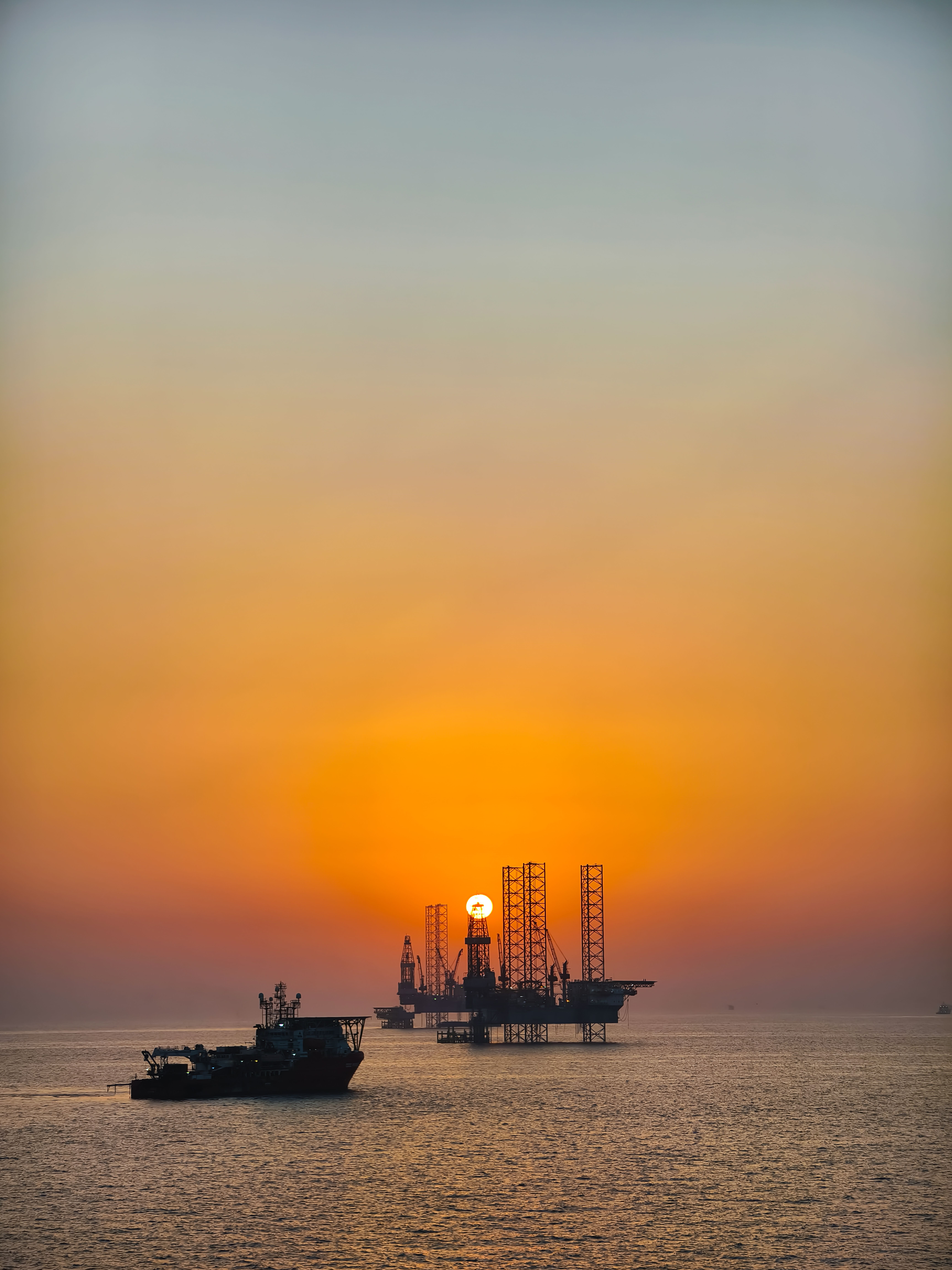 Oil Rig Silhouettes at Sea During Sunset · Free Stock Photo