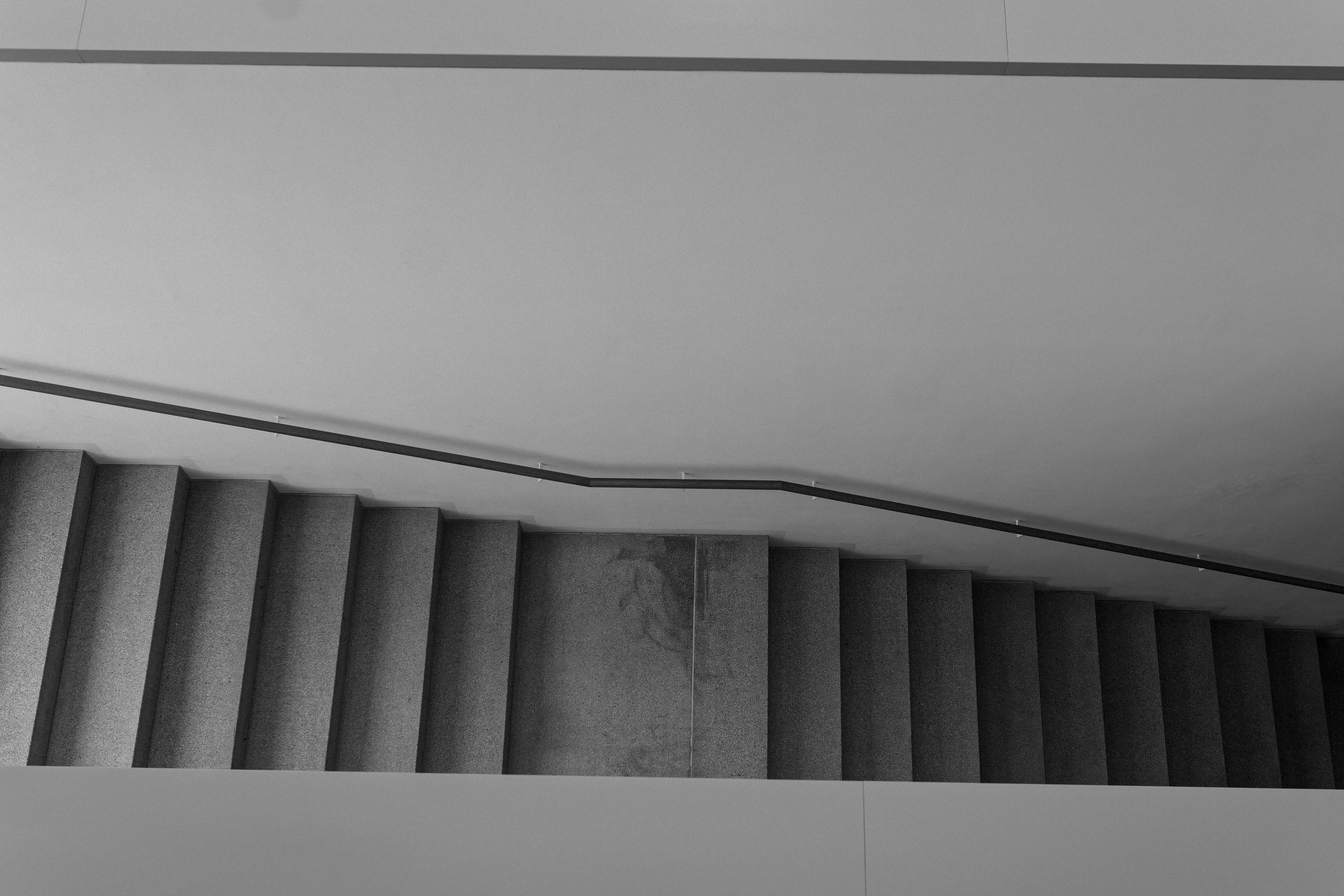 Kostnadsfria En skarp svartvit bild av en modern trappa som erbjuder geometrisk enkelhet. Stock foto