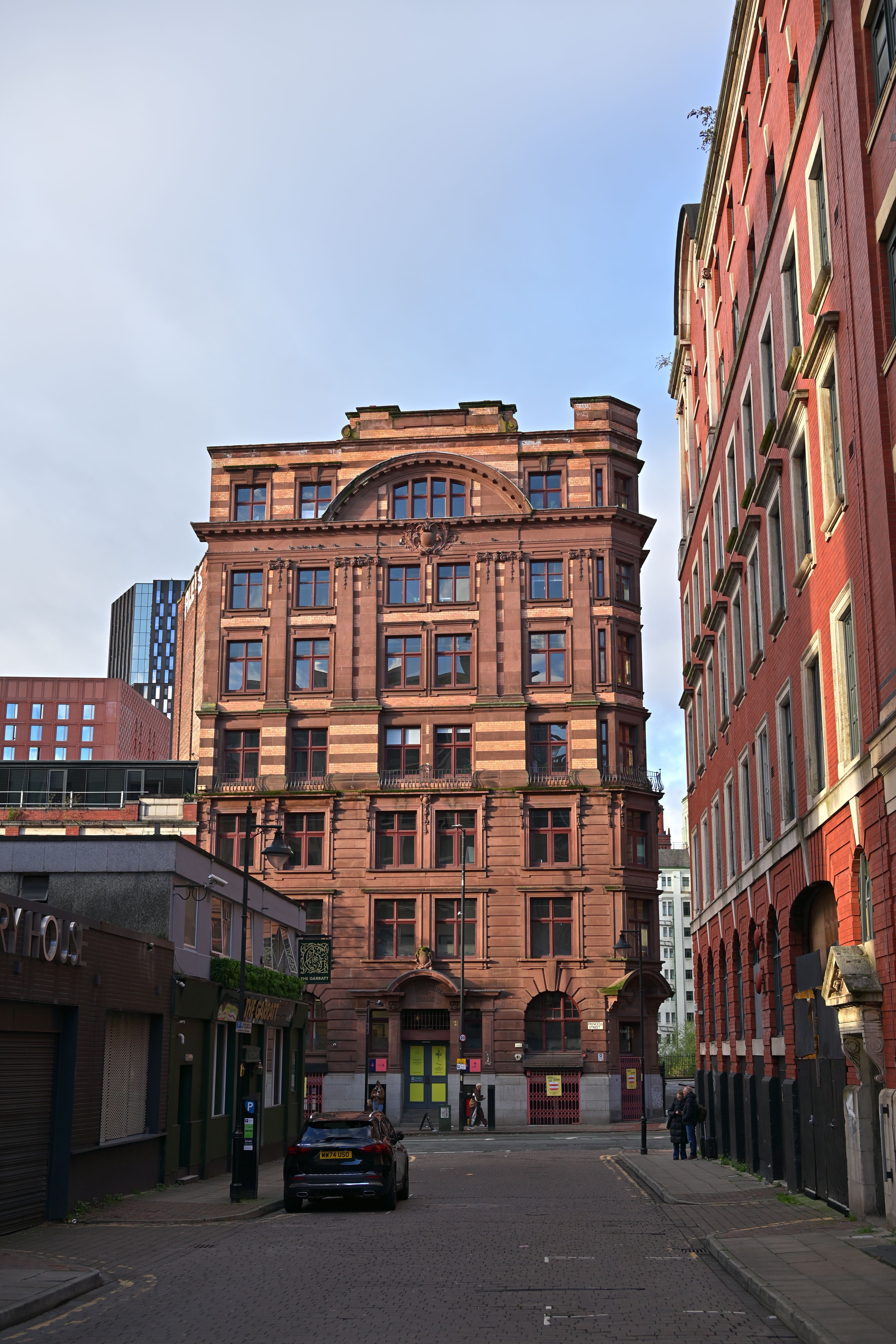 A stunning red brick building on a quiet city street, showcasing classic architectural details.