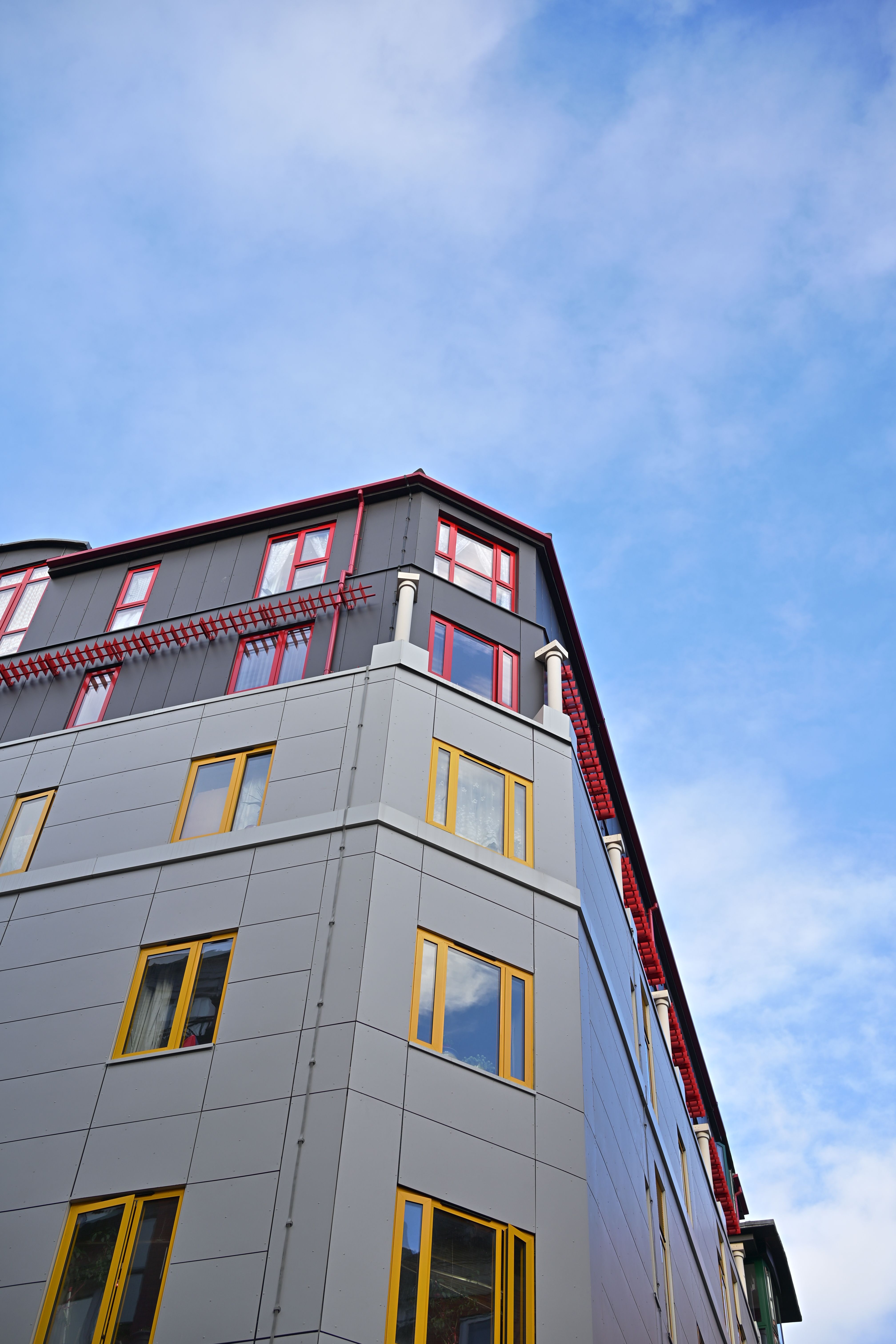 青空を背景にした投資用マンションの外観。立地条件や駅からの徒歩分数も選定基準のひとつになります。